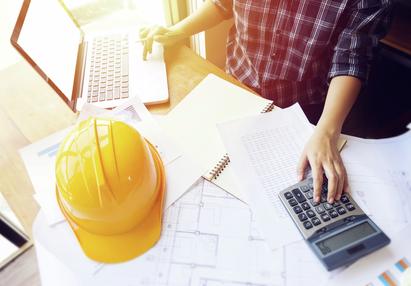 Desktop with computer, hard hat and calculator