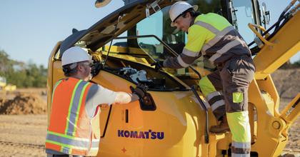 Two technicians working on Komatsu PC88 excavator