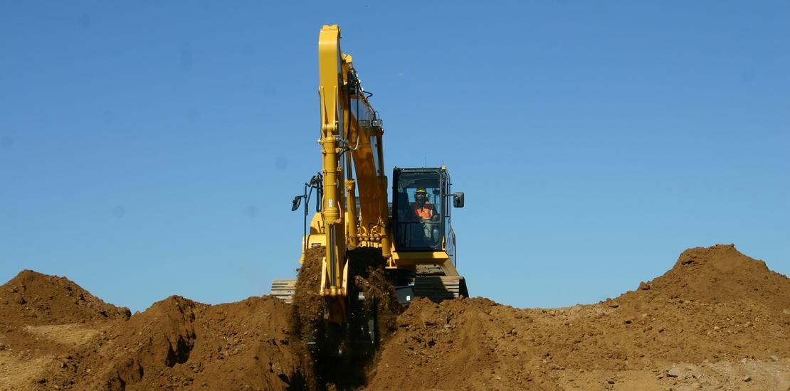 Komatsu PC290LCi-11 excavator scooping dirt