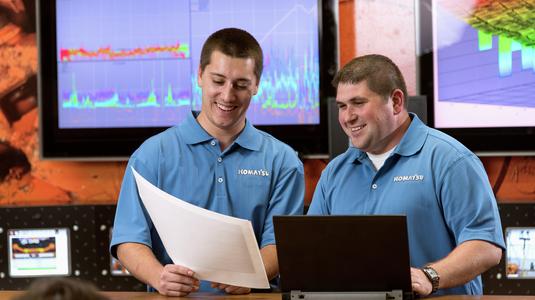 Two Komatsu employees reviewing data