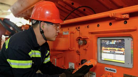 Miner looking at Faceboss screen on Joy shearer