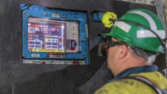 Miner looking at Faceboss software on continuous miner